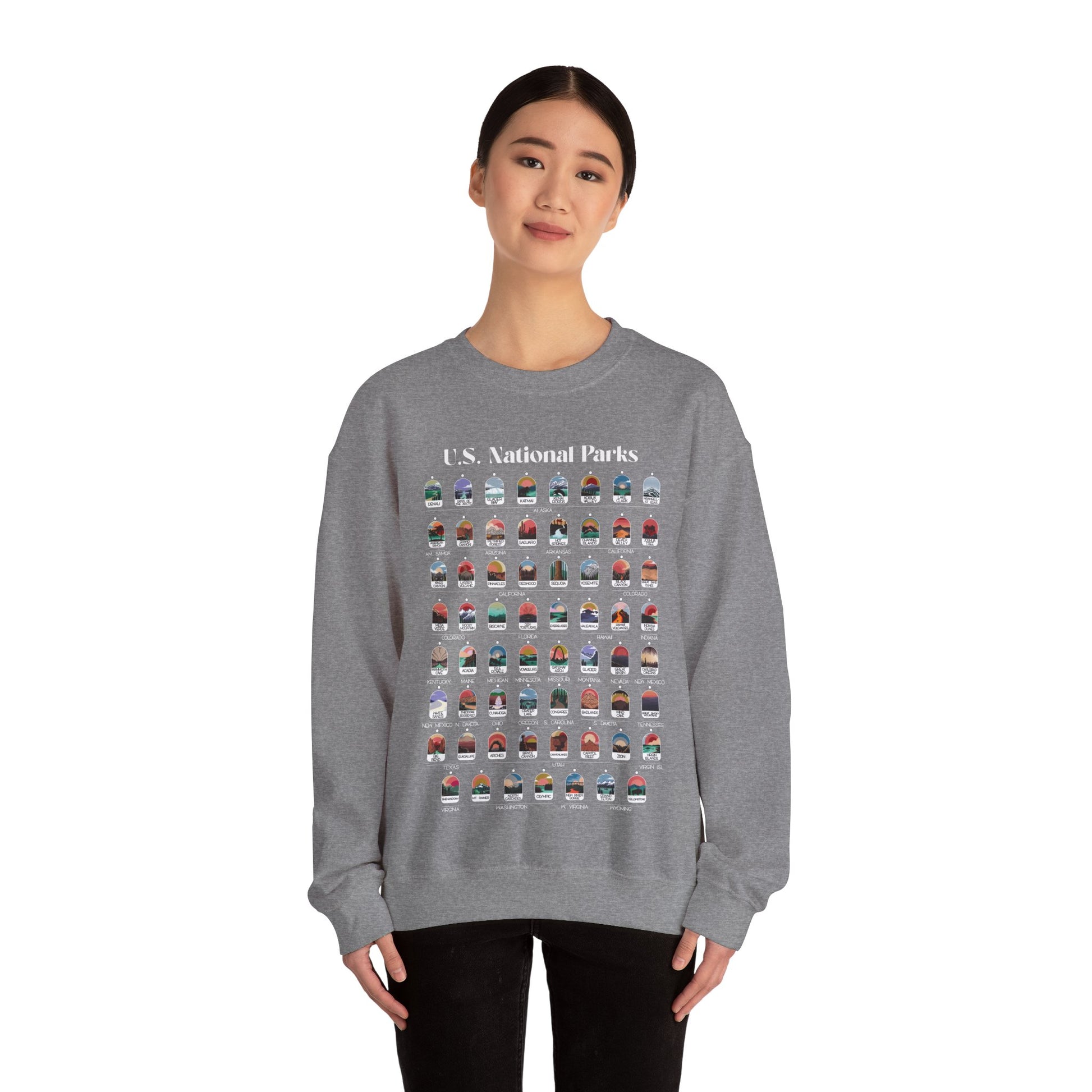 Woman wearing grey colored sweatshirt. Sweatshirt has all 63 National Parks on it with circles to fill in to track your National Parks.