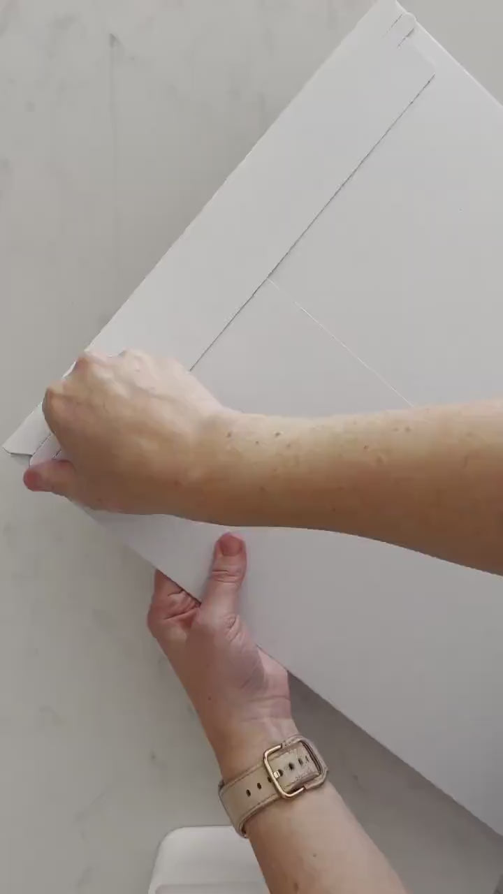 Video of someone opening their package with a National Parks scratch off poster inside. Using the pick that comes with it they scratch off parks to reveal a colorful icons. And then it is hung up.