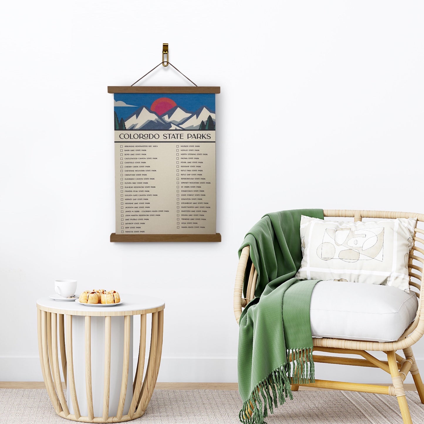 Colorado State Parks Checklist Tracker with marker. Printed on canvas. Has a design on the top with a mountain and sun. Hanging on a wooden frame on a wall.