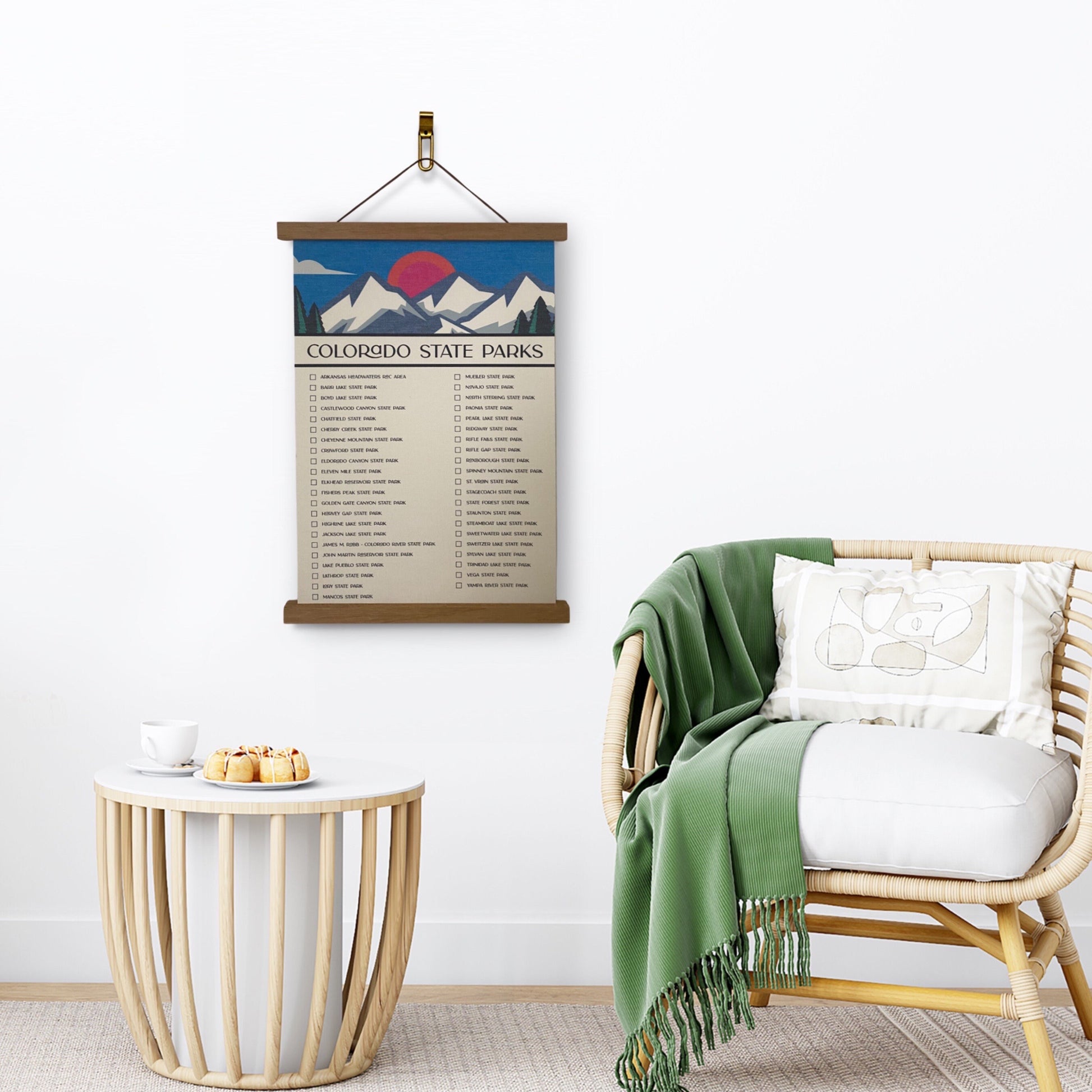 Colorado State Parks Checklist Tracker with marker. Printed on canvas. Has a design on the top with a mountain and sun. Hanging on a wooden frame on a wall.