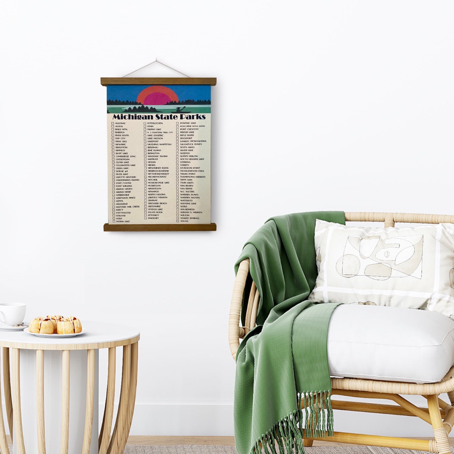Michigan State Parks Checklist Tracker. Printed on canvas. Has a Design on the top with a sunset and canoe. Hanging on a wooden frame on a wall.