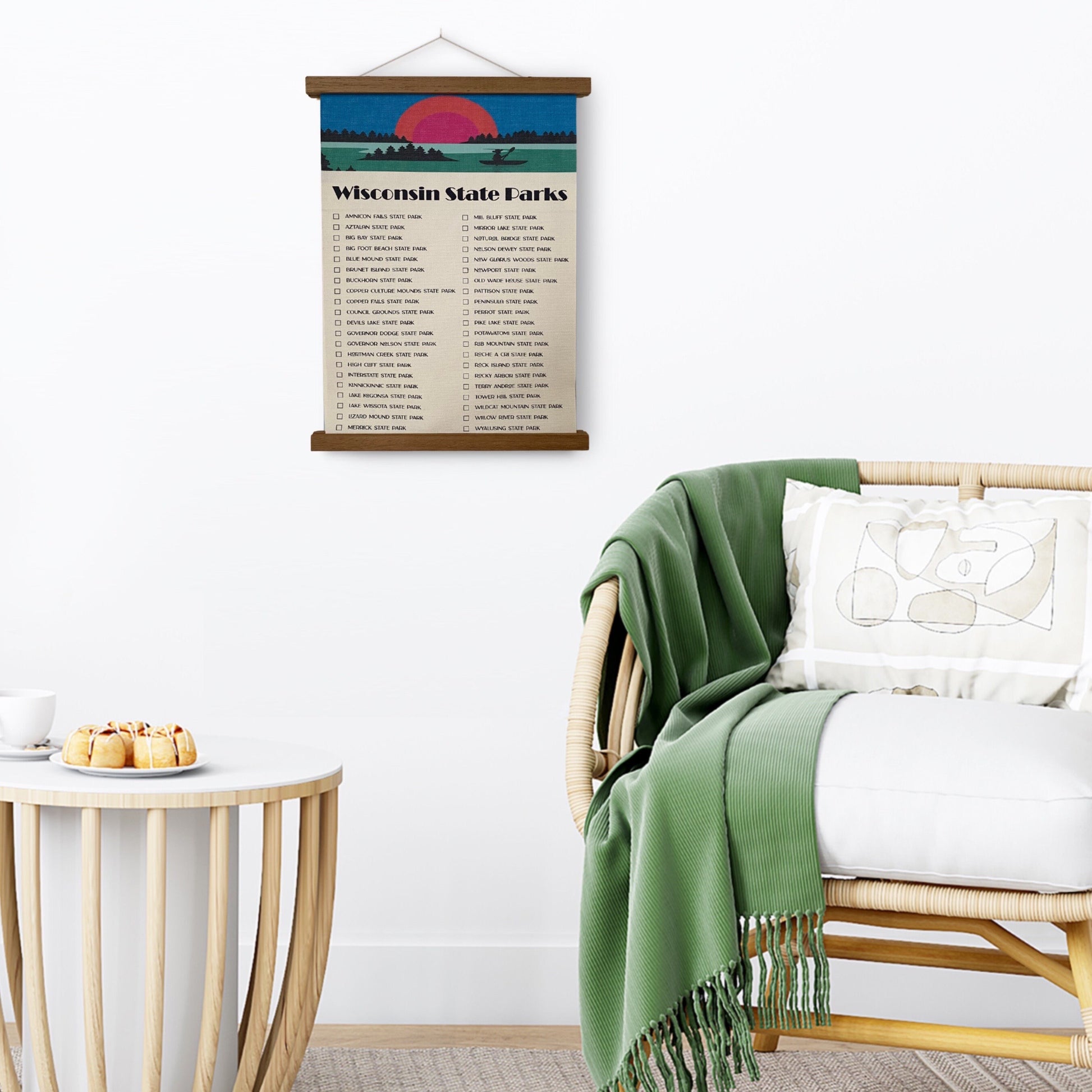 Wisconsin State Parks Checklist Tracker with a marker. Printed on canvas. Has a design on the top with a sunset and canoe. Hanging on a wooden frame on a wall.