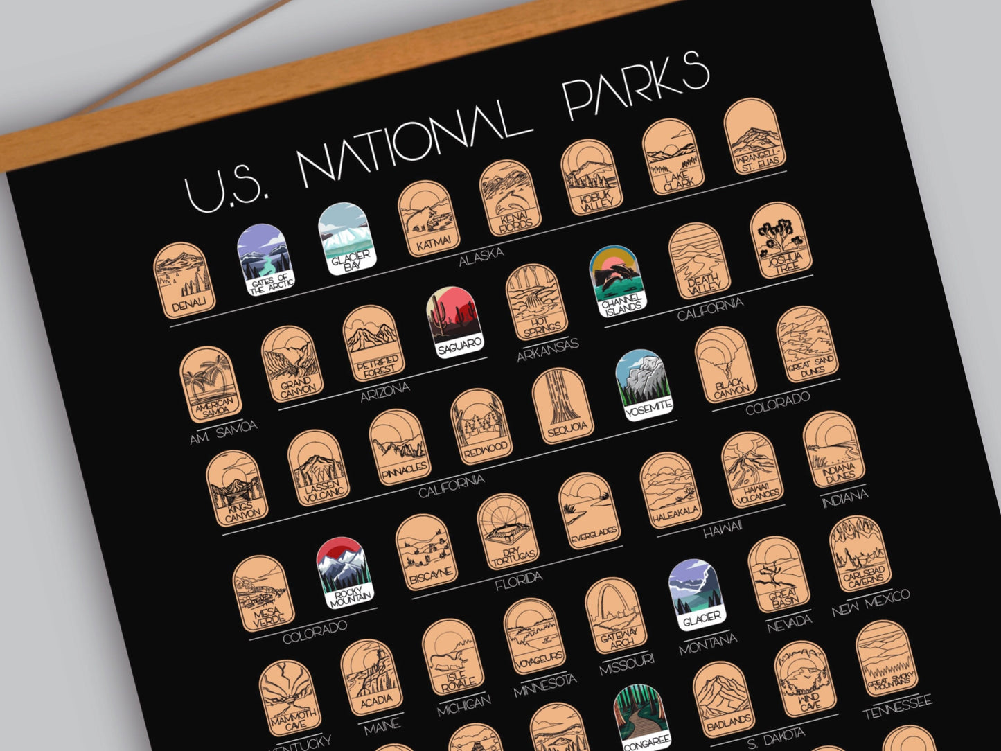 63 National Park scratch off poster, Has a black background with colorful icons for each park. Scratch off a gold layer to reveal artwork. Hanging on a wooden frame.